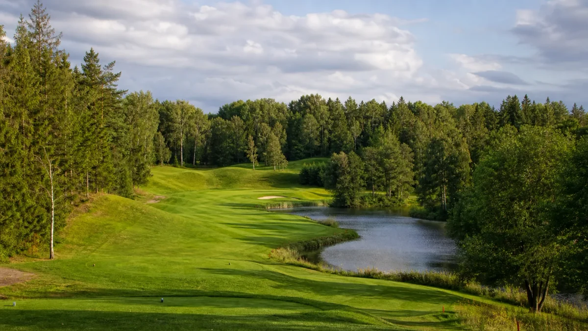 Fairway med skog, parkmark, vatten och kupering på 18-hålsbanan